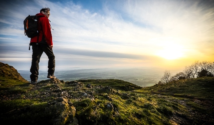 Walker on hill top in The Wrekin overlooking the countryside